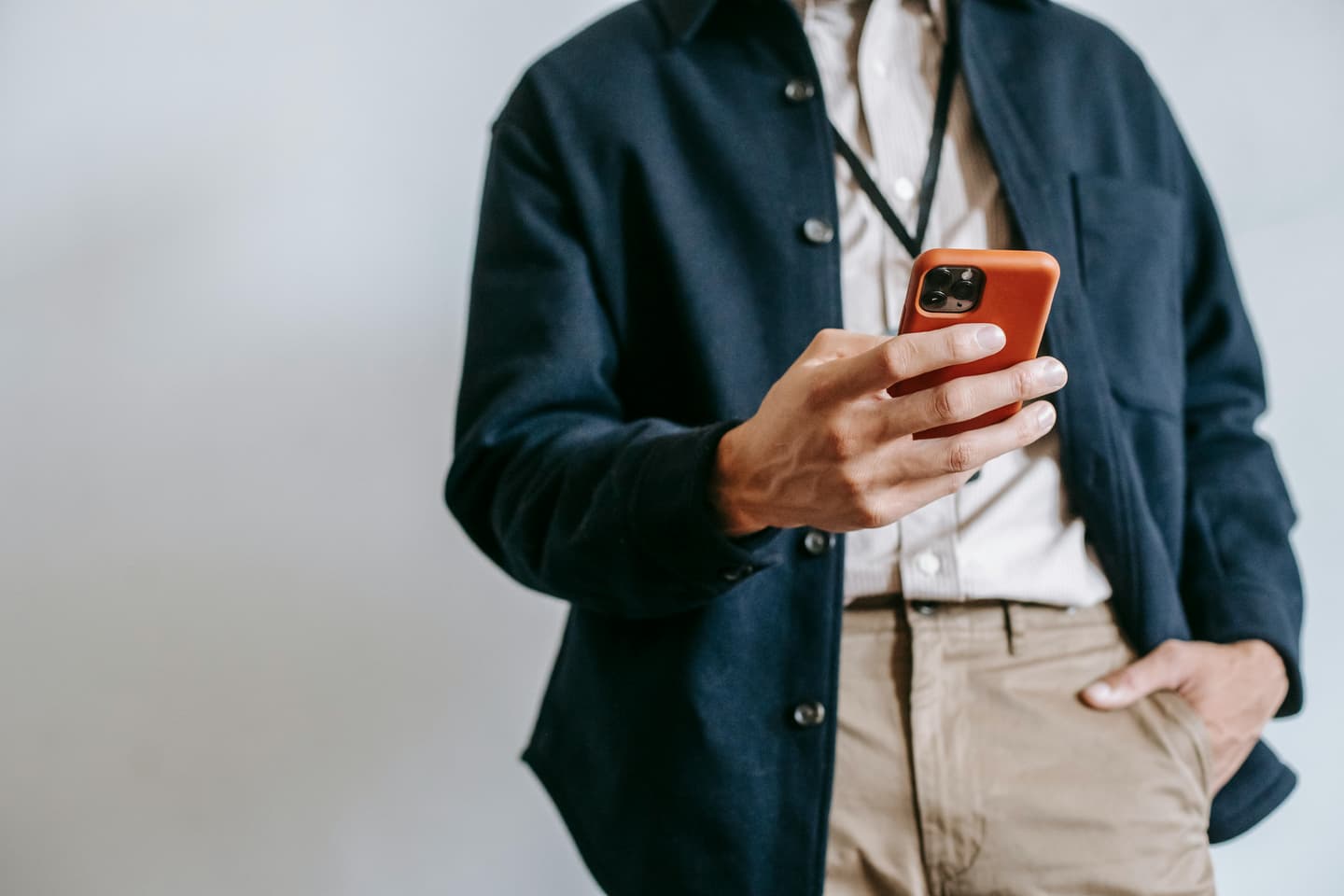 Person in a navy jacket holding a smartphone