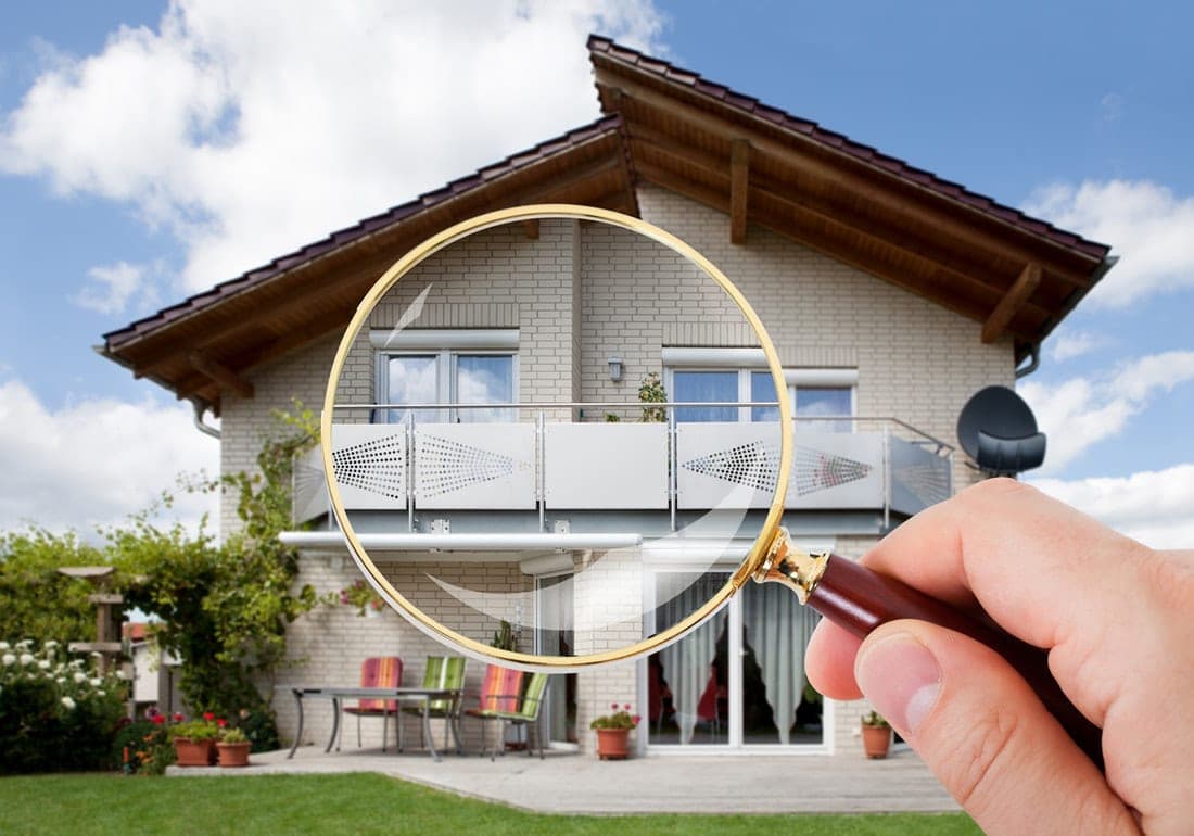 Magnifying glass held up to a two-storey house